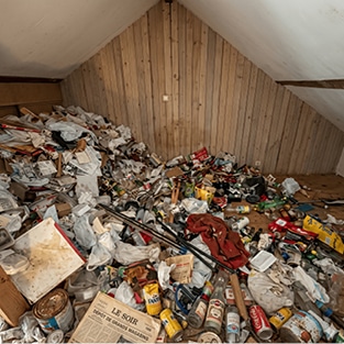 Grenier rempli de détritus avant l'intervention de vide-maison liégeois