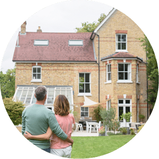 Couple devant une maison qu'ils viennent d'acheter