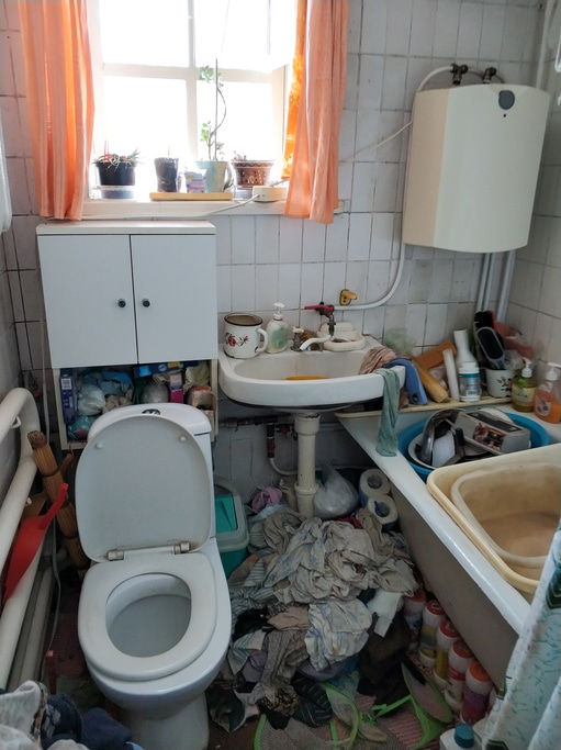 Salle de bain encombrée et sale avant le passage d'un service de vide maison et de nettoyage du syndrome de diogène