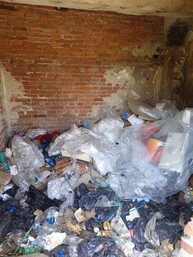 Cave encombrée de détritus avant le passage d'un service de nettoyage et de désencombrement dans la Province de Liège